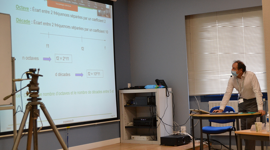 Un homme projette un cours en ligne  sur un écran géant
